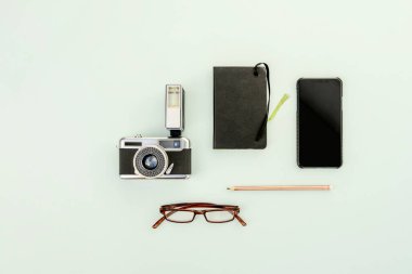 Flaş, altın kalem ve akıllı telefondan oluşan klasik bir kamera içeren bir fotoğraf stüdyosunun en iyi görüntüsü..
