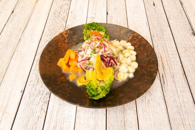Tatlı patates küplü balık ceviche tabağı, muz cipsi, marul tomurcukları ve marine edilmiş kırmızı soğan.