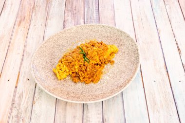 Gri bir tabakta tipik bolonez soslu fettucine makarna.