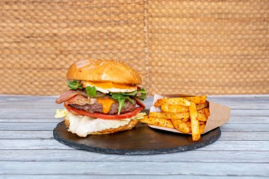 İçinde bol miktarda malzeme ve patates bulunan harika sığır etli burger.