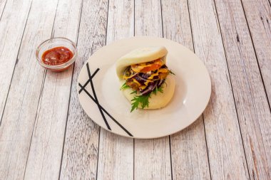 Japon usulü kızarmış tavuk bao roka, domates, kırmızı soğan ve sos.