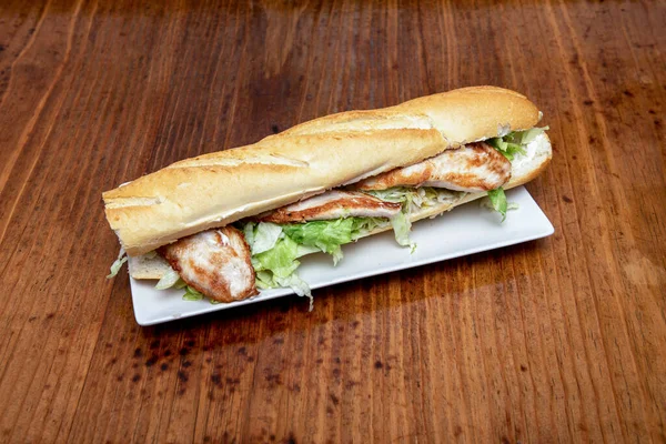 スペイン料理店の典型的なバゲットパンに鶏の巨大なサンドイッチ — ストック写真