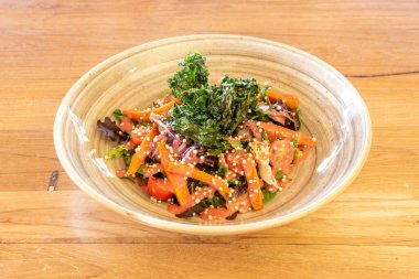 Lezzetli ve sağlıklı sebze salatası ve güzel bej bir porselen kasede ahşap masada lahana.