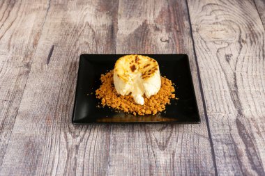 Cheesecake on cookie ground on black plate