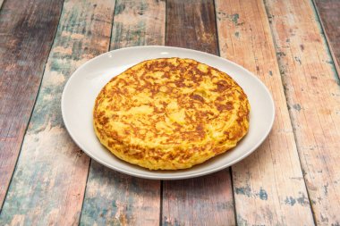 Appetizing Spanish potato omelette made in Spanish tapas bar on white plate