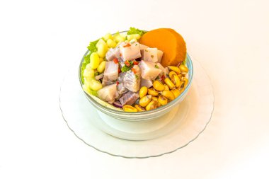 Peru balık ceviche ile dolu cam kase, kanka, tatlı patates ve beyaz arka planda marul..