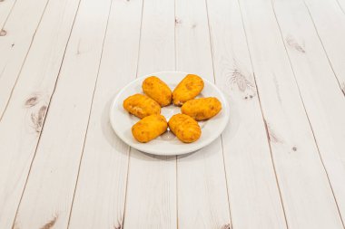 Siyah arka planda taze yapılmış İber jambonlu kroket porsiyonu.