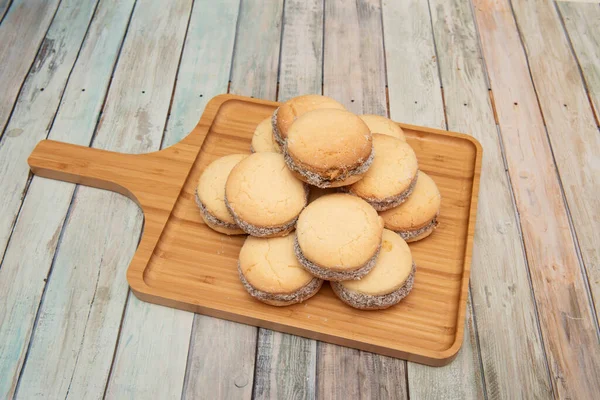 Stack Argentine Alfajores Filled Chocolate Coconut Shavings Bamboo Wood Board — Stock Photo, Image