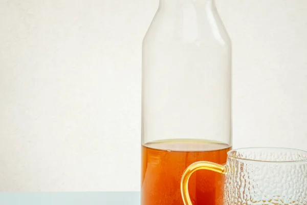 Fles Glazen Kopje Met Thee Pastelblauwe Tafel Witte Ondergrond — Stockfoto