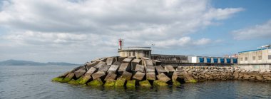 Galiçya, İspanya 'nın Pontevedra haliçindeki deniz feneriyle dalgalı su.