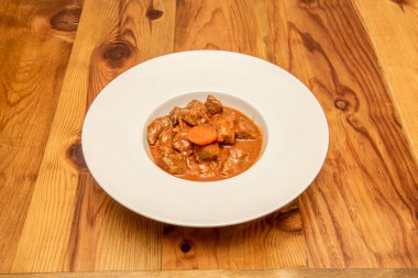 Ahşap masada sebzeli yahni yahnisi.