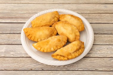 Tipik Arjantin börekleri. Beyaz plastik bir tabakta etle doldurulmuş.