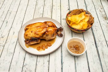 Kızarmış tavuk soslu ve patates kızartması beyaz masada.