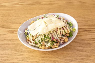 Marullu tipik Sezar salatası, parmesan peyniri ve maydanozlu mayonez, beyaz kase ve meşe ağacından yapılmış.