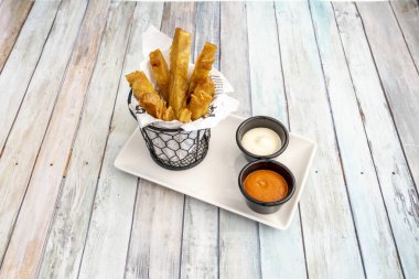 İspanyol restoranında ahşap masa üzerinde tapas servis etmek için bir kase soslu patatas bravas tarifi.