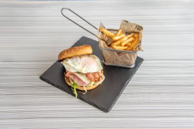 Yağda yumurtalı leziz sığır burger. Böylece üzerinde patates kızartması sepeti ile lekelenmeden yemeye çalışırlar.