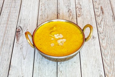 Geleneksel Hindu sarı korma tavuk tarifi Avrupa 'da popüler bir Pakistan restoranının geleneksel bir kasesinde.