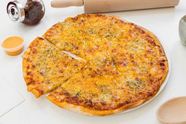 delicious four cheese pizza with a slice cut ready to give you a wild and eager bite on white plate