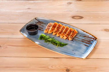 Soya soslu somon tataki tarifi ve mavi tabakta yosun salatası ve ahşap masa.