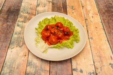 Domates soslu köfte ve salata yapraklı maydanoz.