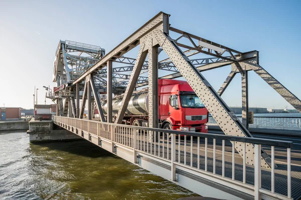 红色油罐车穿过一座吊桥 桥上有许多铆钉穿过安特卫普港 — 图库照片
