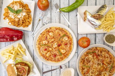 Pizza kebabı, soğan ve tavuk eti, peynirli spagetti, patates kızartmalı hamburger, alüminyum folyo ve çatalla sarılmış lahana ezmesi.