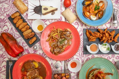 İspanyol yemek yemeklerinin en üst görüntüsü. Jambonlu kroket, deniz ürünleri çorbası, biberli biftek, domuz yanağı, kırmızı biber, ekmek, biber..