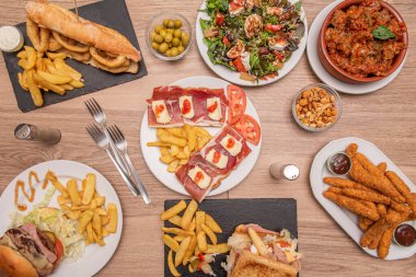 Tapas restoranı için yemek tabakları ve paylaşmak için. İberya usulü jambonlu tost, tavuk parmağı, soslu et, hamburger, kalamar sandviçi.