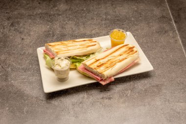 Küba usulü jambonlu sandviç, peynirli Tranchete, buzdağında marul, yayılmış ve ızgara ekmek.