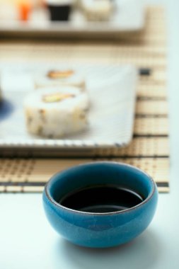 Japon suşi restoranının masasında soya sosuyla dolu mavi taş kâse.