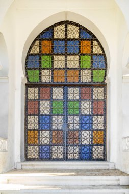 Karakteristik kemerli Arap mimari tarzı kapı, dökme demir metal çit ve renkli cam.