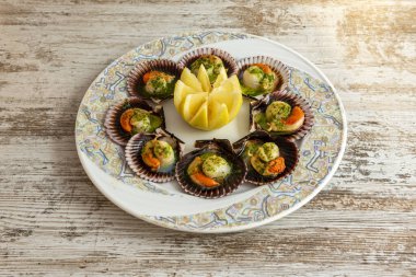 Kuzeybatı İspanya 'da bir Galiçya restoranında pişirilen yeşil soslu etkileyici istiridye tabağı.