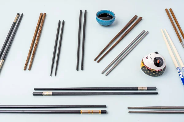 Ζεύγη Chopsticks Διαφόρων Τύπων Και Εξαρτημάτων Τοποθετημένα Αυθαίρετα Μπλε Φόντο — Φωτογραφία Αρχείου