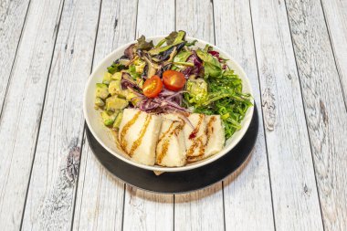 Kalın soya peynirli vejetaryen dürüm kasesi, salsa soslu avokado, kırmızı soğan, vişneli domates, marul filizi ve wakame yosun salatası.