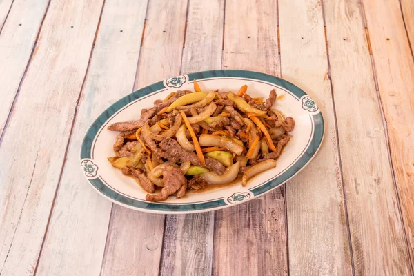 Tiras de ternera salteadas al wok con verduras, cebollas y zanahorias cocidas en un restaurant chino
