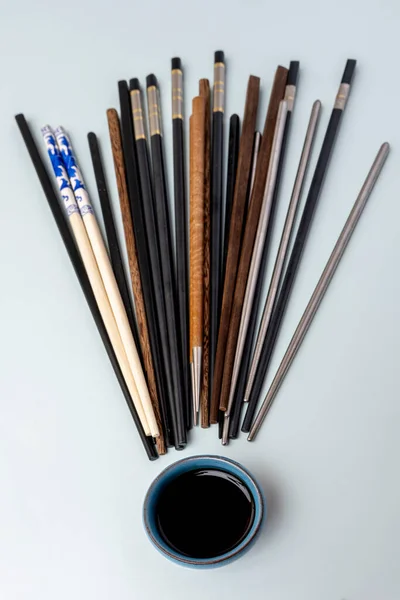 中国筷子 颜色和材料各异 蓝底上有酱油 — 图库照片