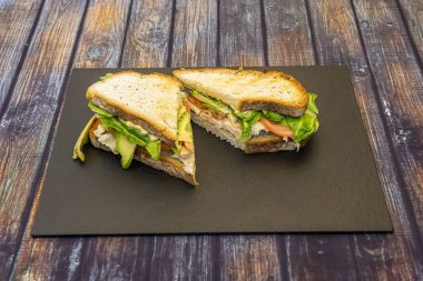 İspanyol köyünün ekmekli sandviçi tavuk göğsü fileto, olgun avokado, domates ve sebzeli mayonez.