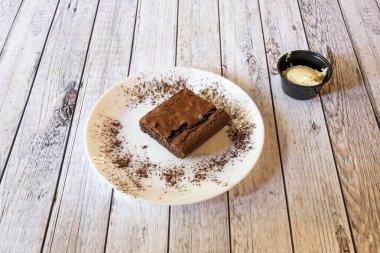 Fındıklı çikolatalı kek, kakao tozu ve vanilyalı dondurma.