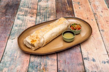 Tavuk, pirinç ve fasulye ile doldurulmuş Meksika usulü burrito harika bir sunum. Buğdaylı tortilla tabağa ve guranicion of aji ve pico de gallo 'ya geçti.