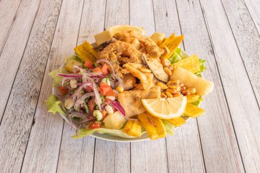 Peruvian recipe Jalea of seafood and vegetables battered and fried with red onion with various types of corn grains