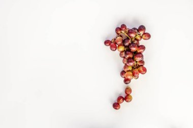 Tepeden bakıldığında beyaz arka planda bir demet kırmızı tatlı üzümü