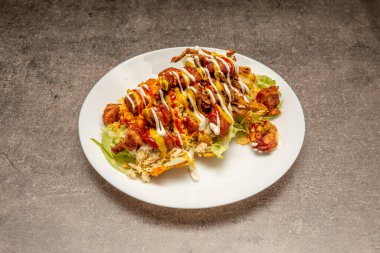 Bol soslu Kolombiya patatonu, kızarmış torreznos, doğranmış tavuk eti ve marullu olgun muz.