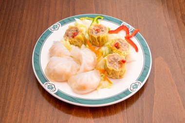 Tahta masada karides, domuz eti ve sebzelerle doldurulmuş Çin Dim Sum tabağı.