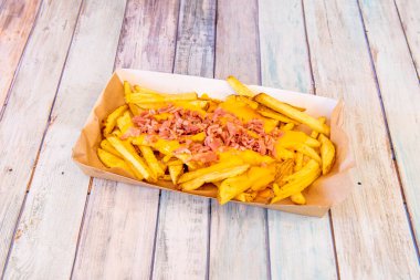 Ev yapımı harika cips, erimiş çedar peyniri ve karton tepside kızarmış domuz pastırması.