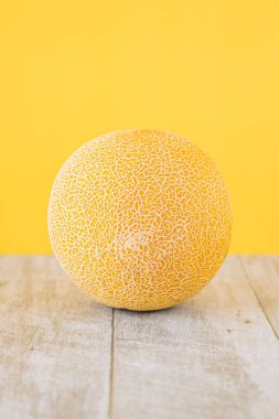 Sarı Galya kavunu ahşap masada ve sarı arka planda