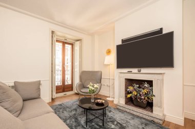 Oturma odası kanepe, sehpa, mermer şömine ve büyük düz ekran televizyon ve kiralık bir apartmanda ses barı.