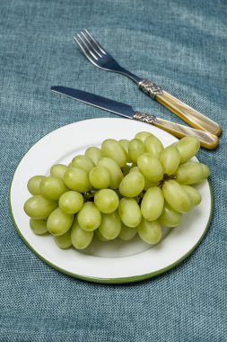 Altın kaplama çatal bıçaklı beyaz üzüm tabağı.