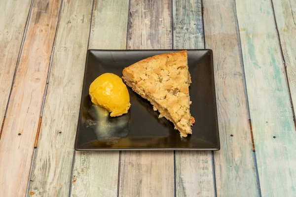 Homemade apple pie slice and mango ice cream scoop
