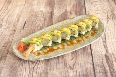 Kızarmış karides, avokado dilimleri ve ginseng 'li wasabi ile Uramaki ejder sarması.