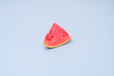 Üçgen porsiyon taze çekirdeksiz karpuz açık mavi masada.